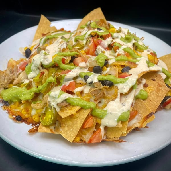Ducks Grille & Bar's loaded nachos with pulled pork, corn, black beans, tomatoes, and sauces.